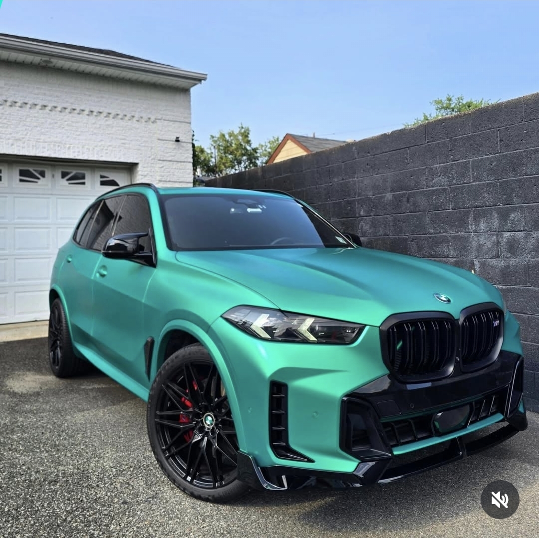 Satin teal BMW X5 M SUV photographed at night